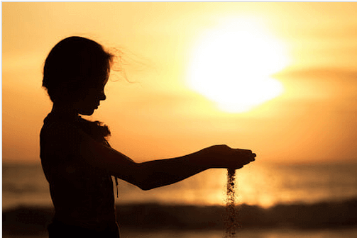 Bambino con sabbia tra le mani