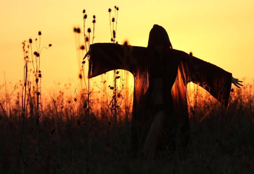 Donna con mantello al tramonto