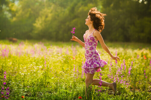 donna felice e che sorride tra i fiori