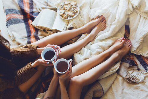 amiche sul letto bevono caffè