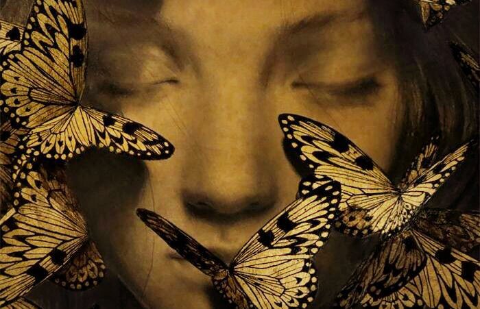 viso di donna circondato da farfalle
