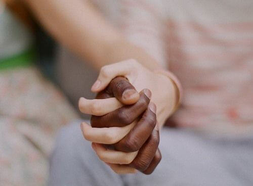 mano bianca e nera che si stringono