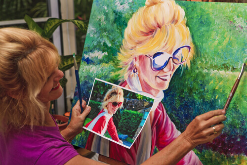 donna bionda dipinge quadro guardando foto