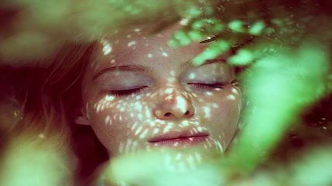 donna che sorride tra le foglie