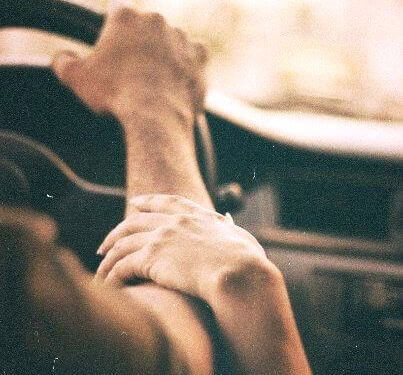 donna-tocca-braccio-di-uomo-al-volante