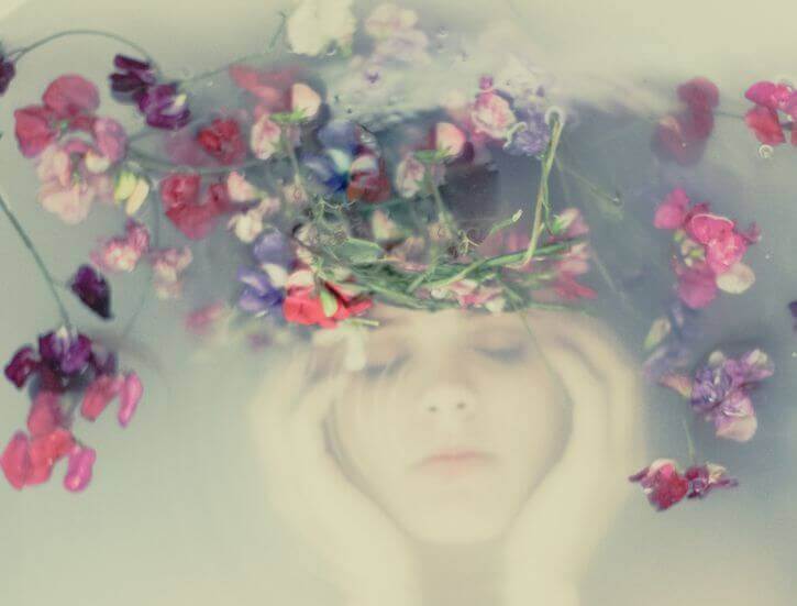 viso di donna sott'acqua e fiori