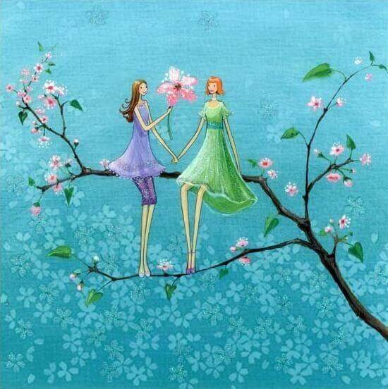 amiche in piedi su un ramo tra i fiori rosa