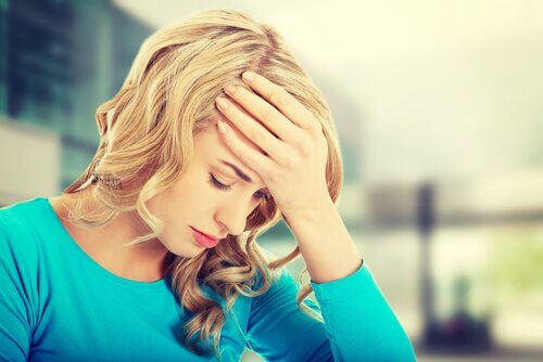 ragazza bionda con mano sulla fronte