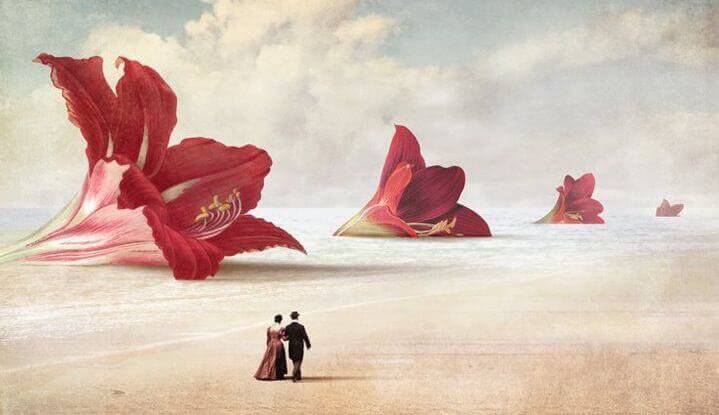 uomo e donna camminano su spiaggia con fiori rossi giganti