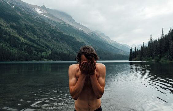 uomo fa il bagno in lago di montagna