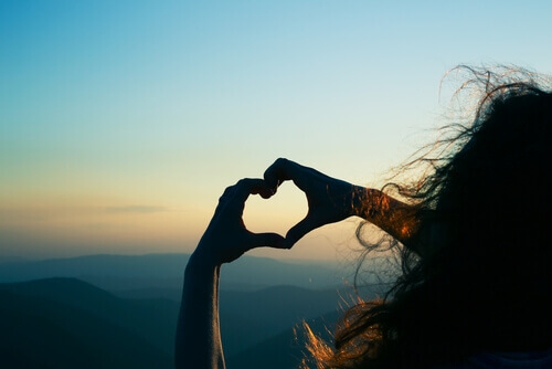 ragazza crea cuore con le mani