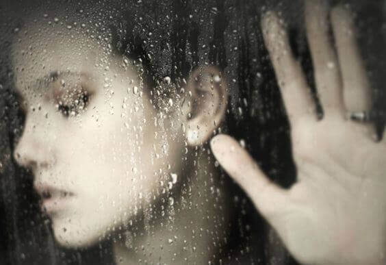 Donna con vetro e pioggia
