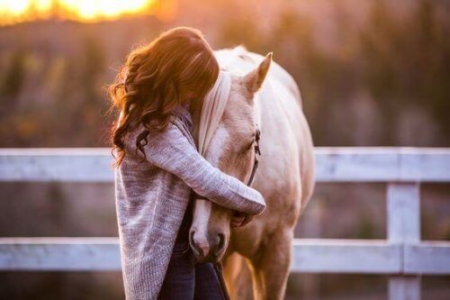 donna che abbraccia un cavallo