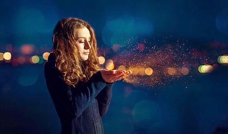 ragazza con polvere luminosa tra le mani