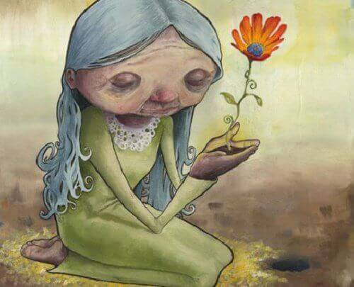 anziana in ginocchia con un fiore che nasce dalle sue mani