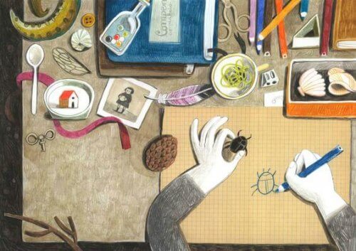 scrivania-con-molti-oggetti-e-persona-che-disegna