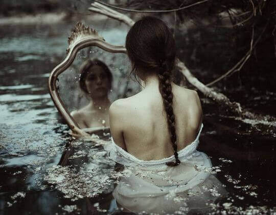 donna triste allo specchio