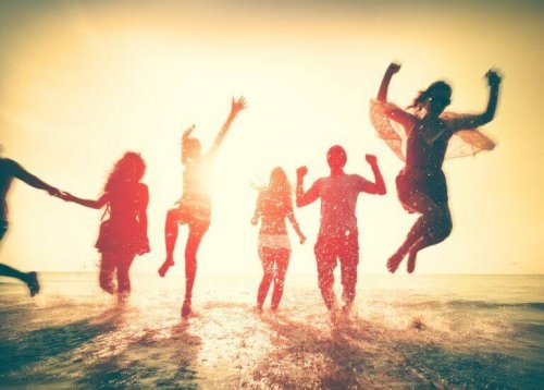 Amici che saltano felici in riva al mare