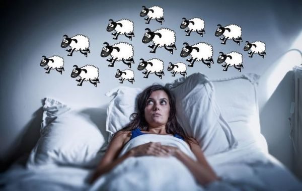 Donna a letto che conta le pecore