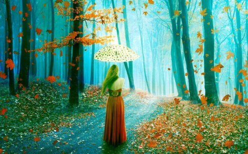 Donna con un ombrello mentre passeggia nel bosco