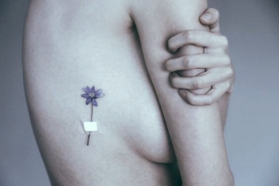 La malattia e donna con tatuaggio a forma di fiore