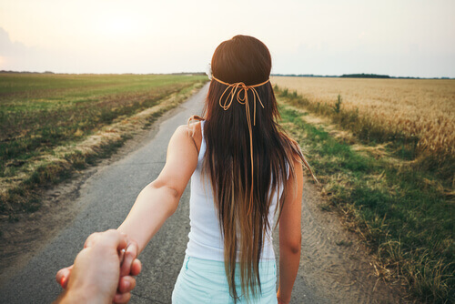 Ragazza di spalle che dà la mano al suo fidanzato