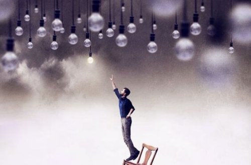 Uomo che cerca di raggiungere lampadine che pendono dal soffitto