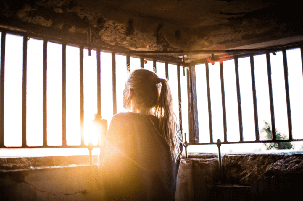 Ragazza guarda oltre una recinzione