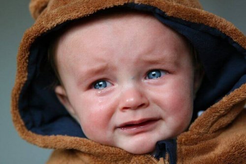 Bambino con gli occhi azzurri che piange