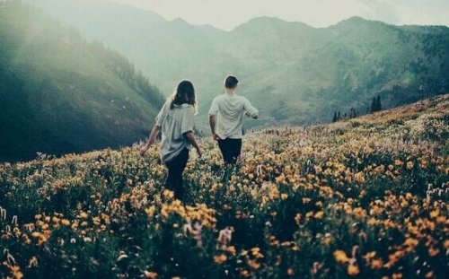 Una coppia che cammina tra i campi di fiori 