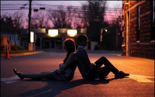 Una coppia giovane seduta in strada