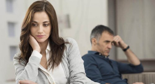 Donna preoccupata, sullo sfondo il suo partner