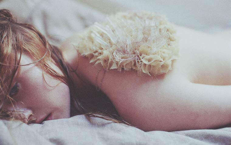 Donna triste sul letto