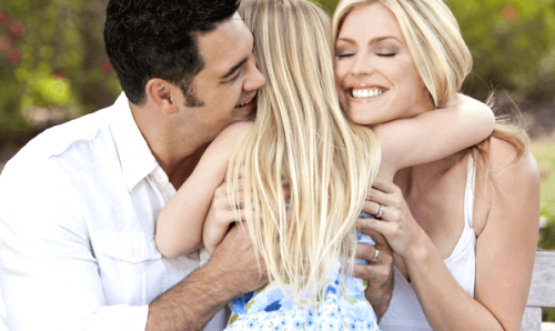 Genitori abbracciano la figlia