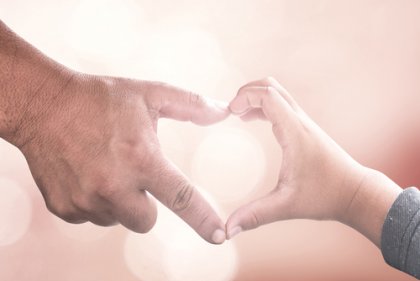 Mani di padre e figlio che formano un cuore