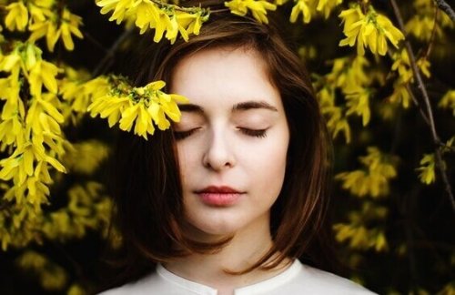 Ragazza circondata da fiori gialli, felice del fatto di stare bene con sé stessa
