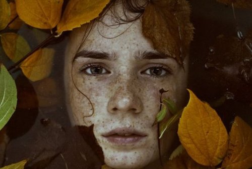 Una ragazza circondata da foglie