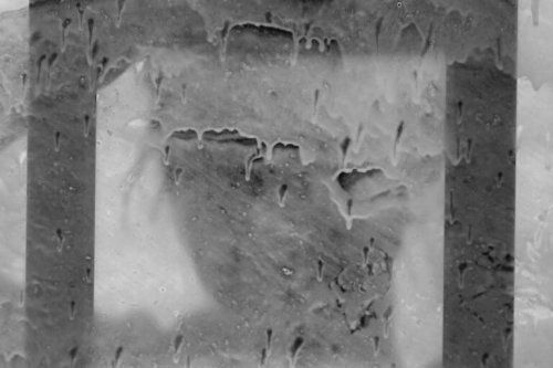 Donna dietro ad un vetro macchiato