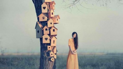 Donna vicino ad un albero con delle casette, mentre pensa a come farsi rispettare
