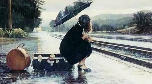 Donna alla stazione sotto la pioggia