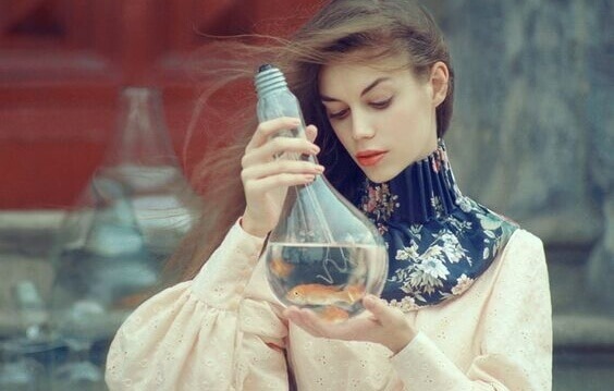 Donna con lampadina con dentro un pesce rosso