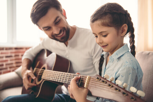 Bambina e papà che suonano la chitarra