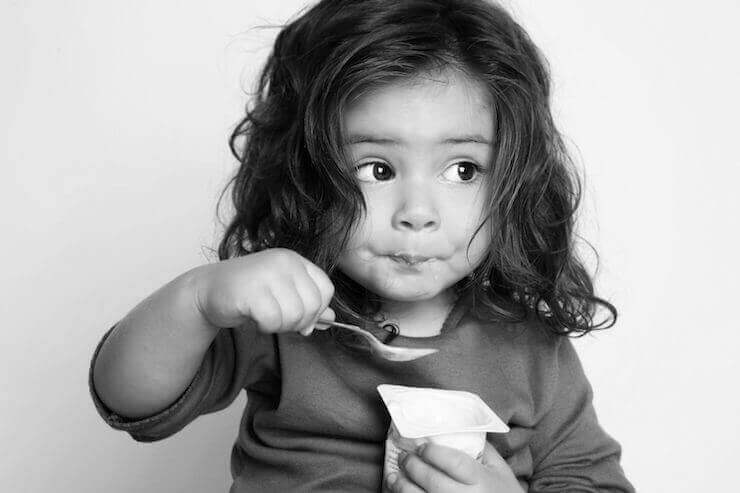 Bambina che mangia uno yogurt
