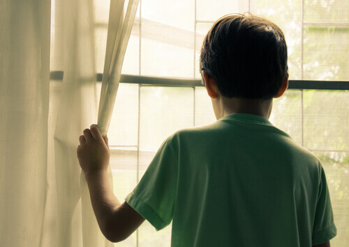 Bambino che guarda fuori dalla finestra