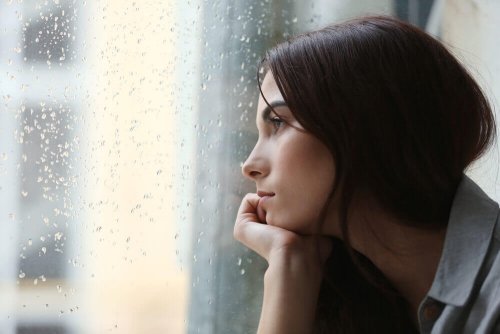 Donna con depressione che guarda dalla finestra