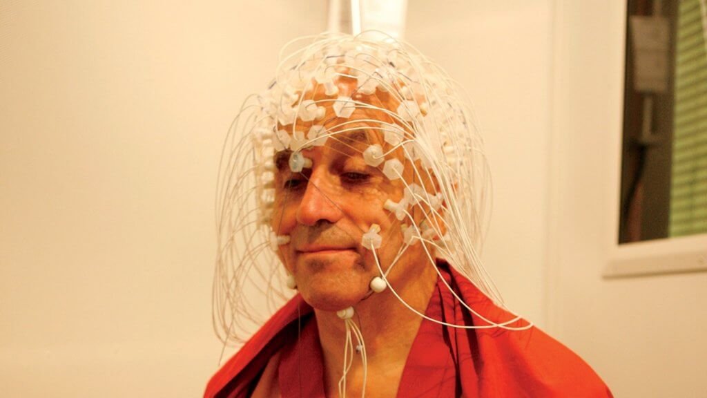 Matthieu Ricard con degli elettrodi in testa