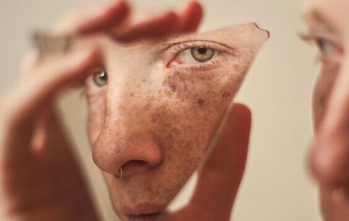 Ragazzo riflesso in un frammento di specchio che cerca di essere il proprio migliore alleato