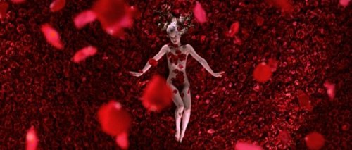 Scena del film American Beauty in cui si vede una donna nuda circondata da petali di rosa