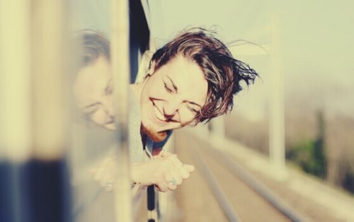 Ragazza sorridente affacciata al finestrino del treno