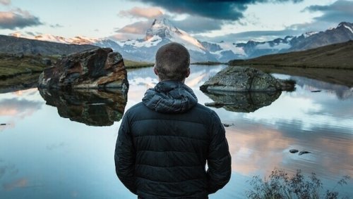 Ragazzo davanti ad un lago come simbolo dell'arte di stare bene con sé stessi